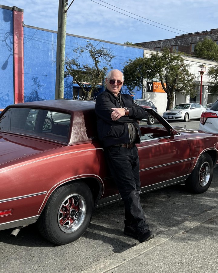 Chris Walker standing beside his classic Oldsmobile